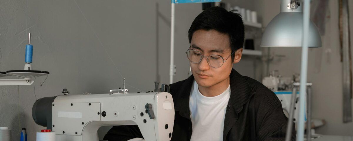 a man sewing fabric on a sewing machine