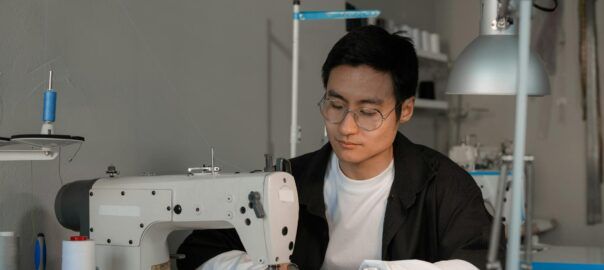 a man sewing fabric on a sewing machine