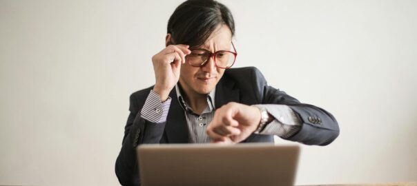 confused businessman checking time on wristwatch