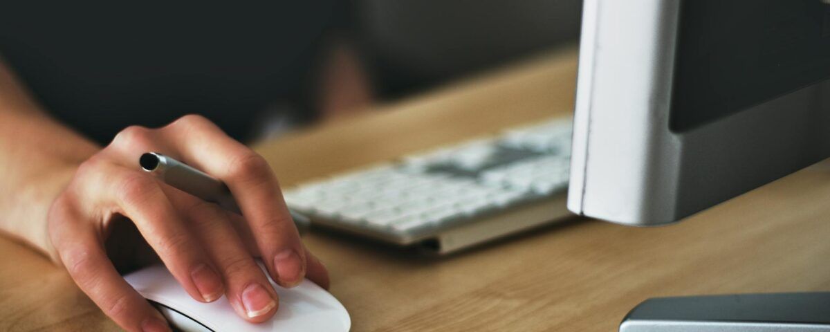 person holding apple magic mouse