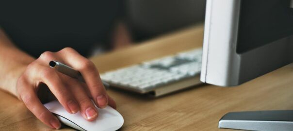 person holding apple magic mouse